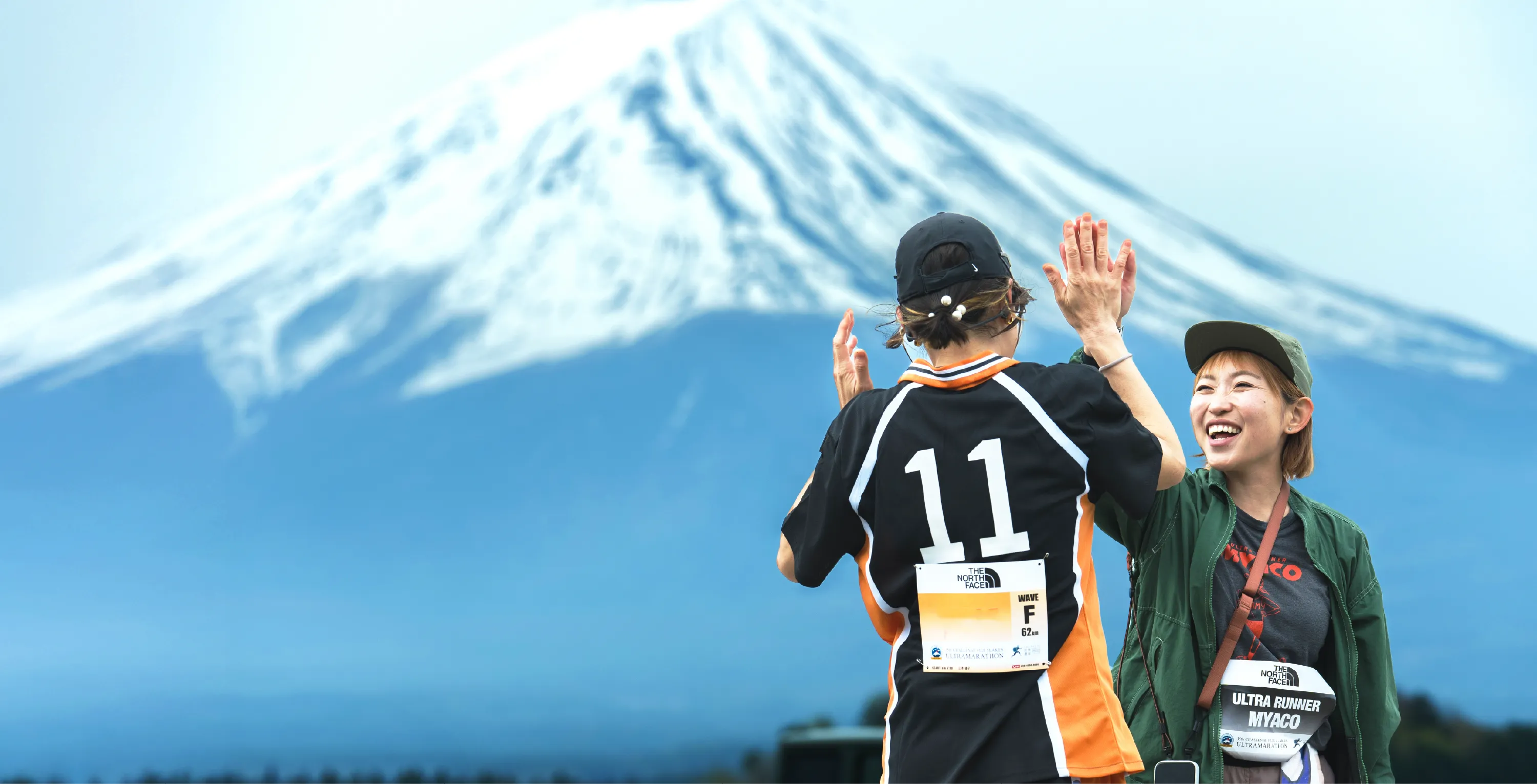 富士山を背景にハイタッチする大会参加者